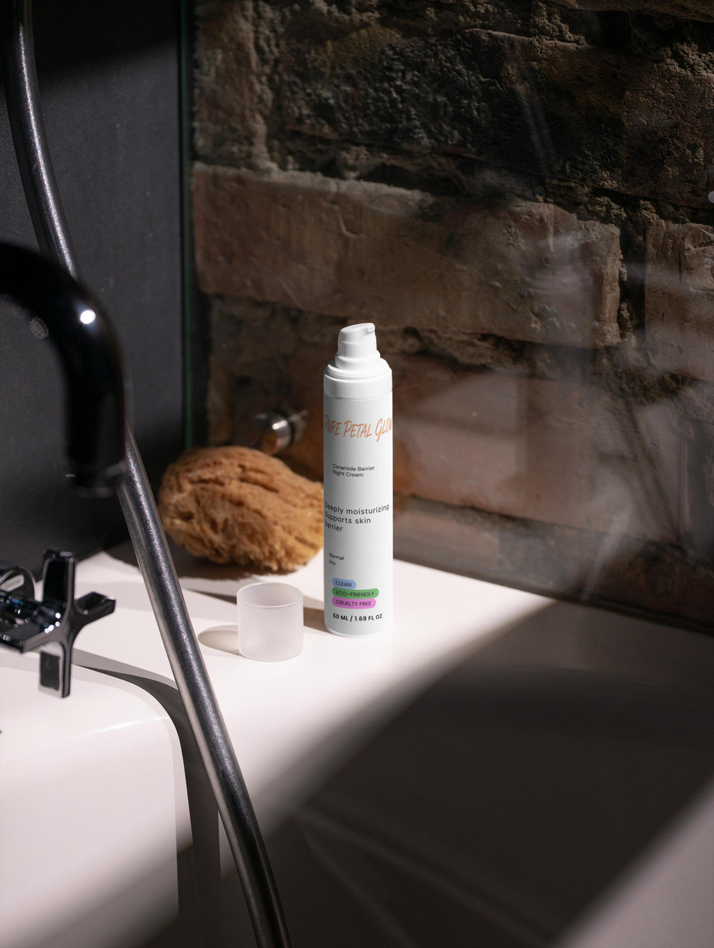 White Ceramide Barrier Night Cream bottle on a bathroom counter with a stone wall background
